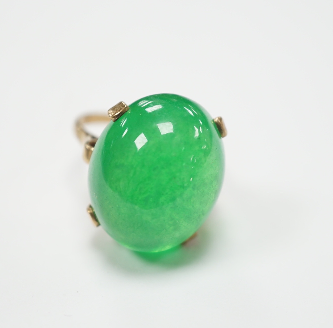 A 9ct and large cabochon oval jade set ring, size P/Q, gross weight 11.6 grams, the stone measuring approx. 21.1mm by 17.4mm, with a depth of 12.4mm.